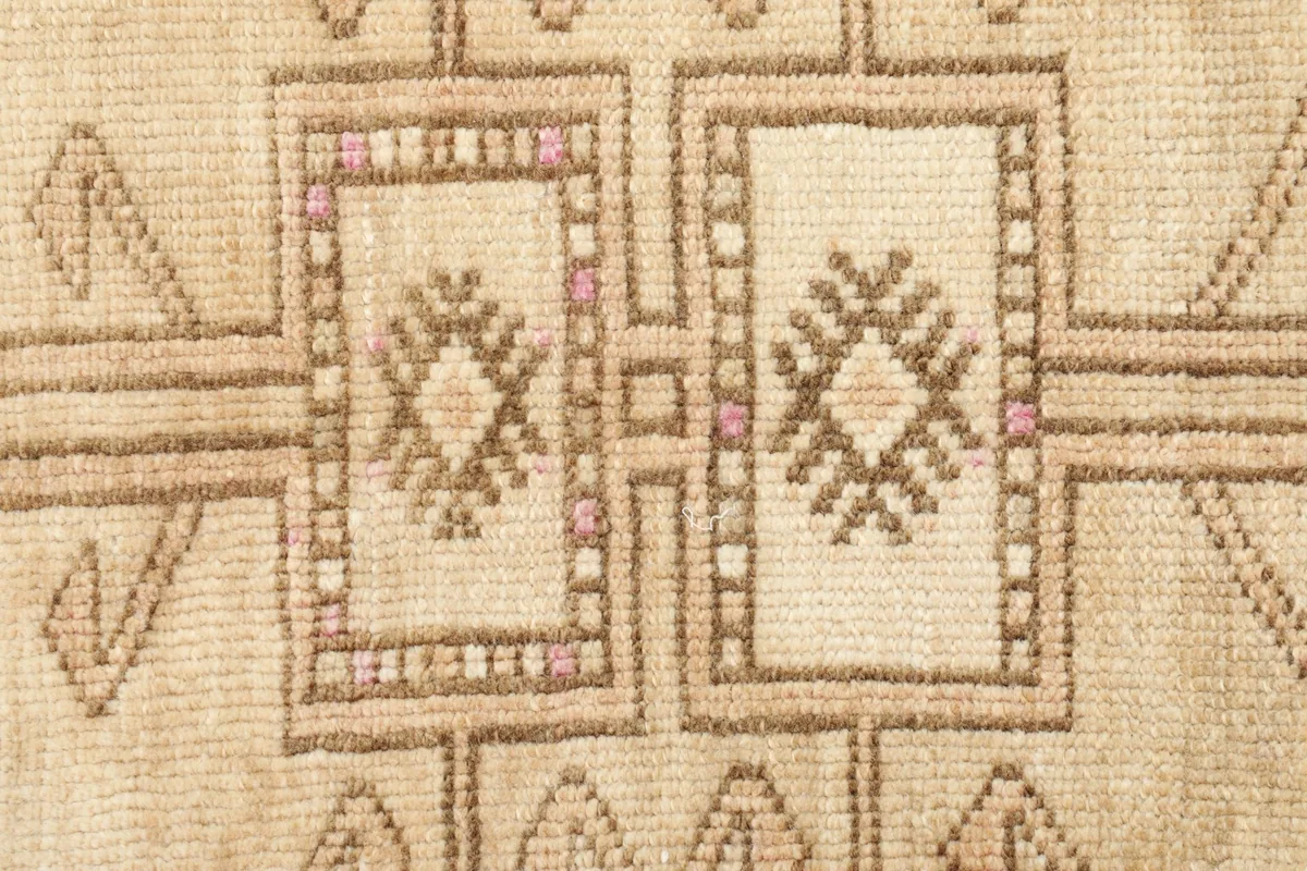 Detailed close-up of the central geometric design, highlighting the brown and pink knotting.