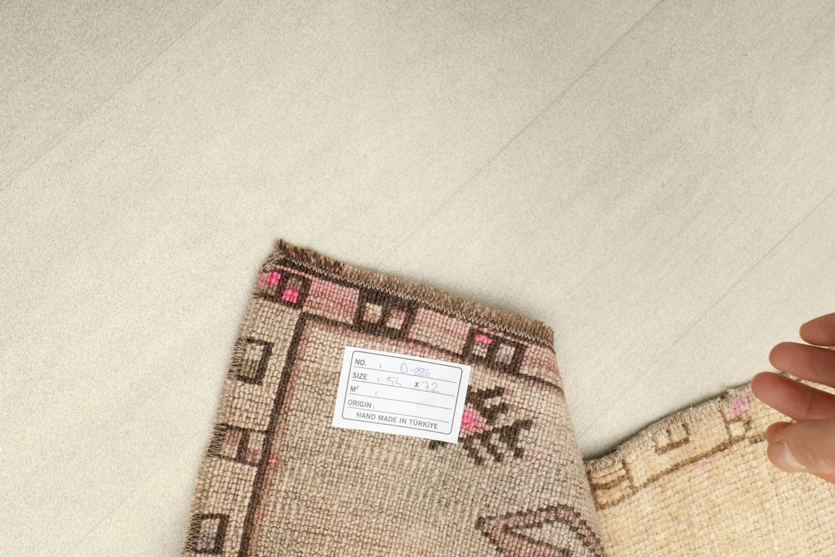 Close-up of the rug's back, revealing the hand-knotted cotton foundation and a product tag.