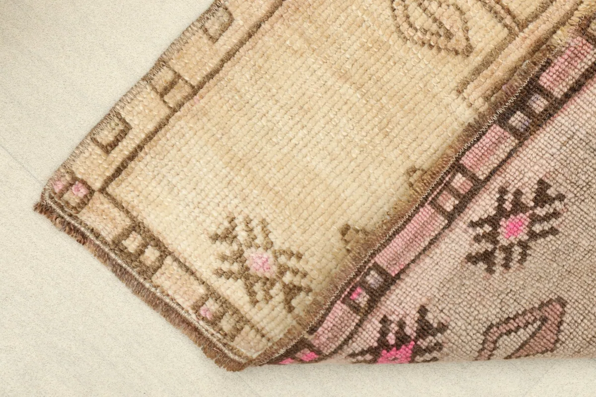 View of the rug folded, showing the soft wool pile on the top and the cotton foundation on the back.