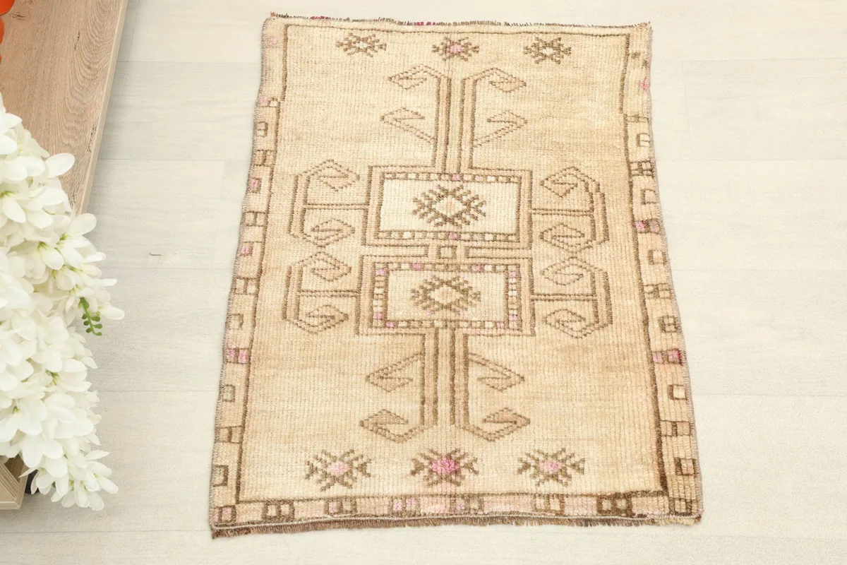 Direct overhead shot of the beige wool rug, showing its full geometric pattern.