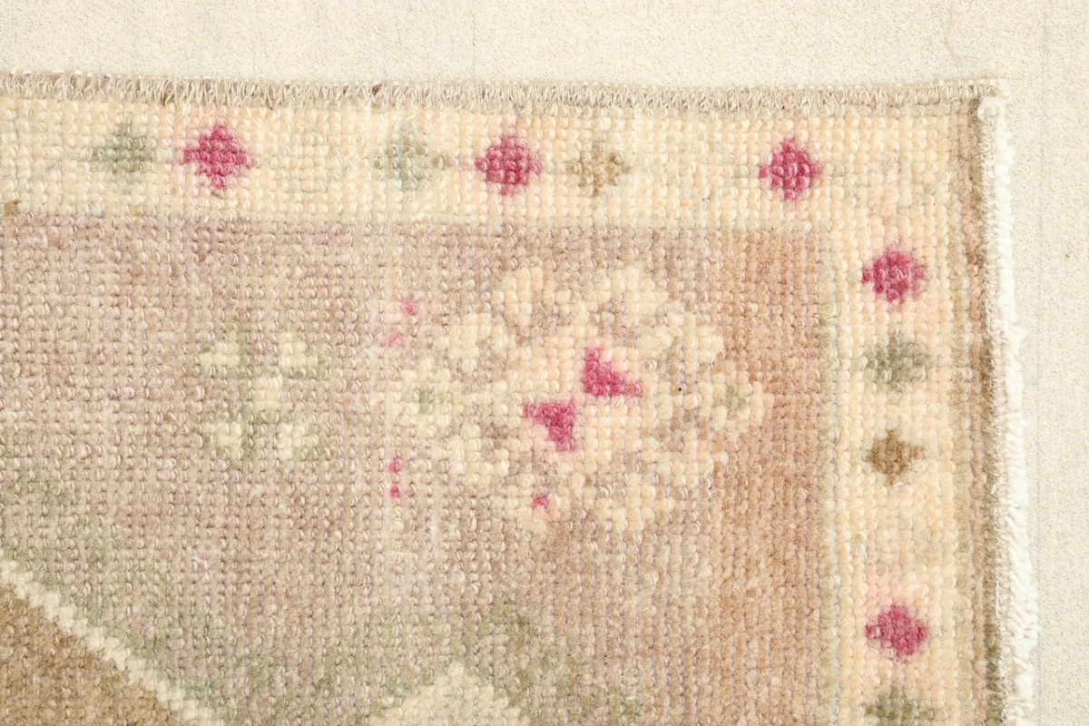 Close-up of the rug's edge and border, displaying the hand-knotted details and fringe.