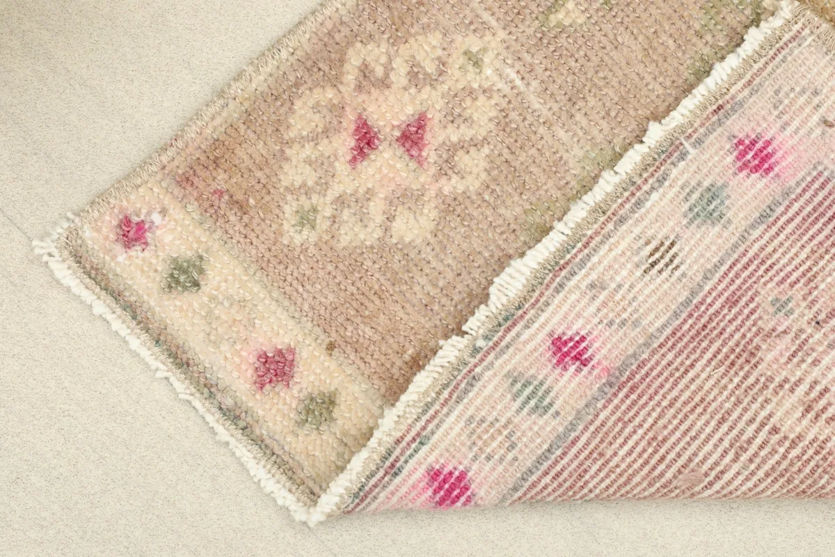 View of the rug folded to show the wool pile on the front and the cotton foundation on the back.