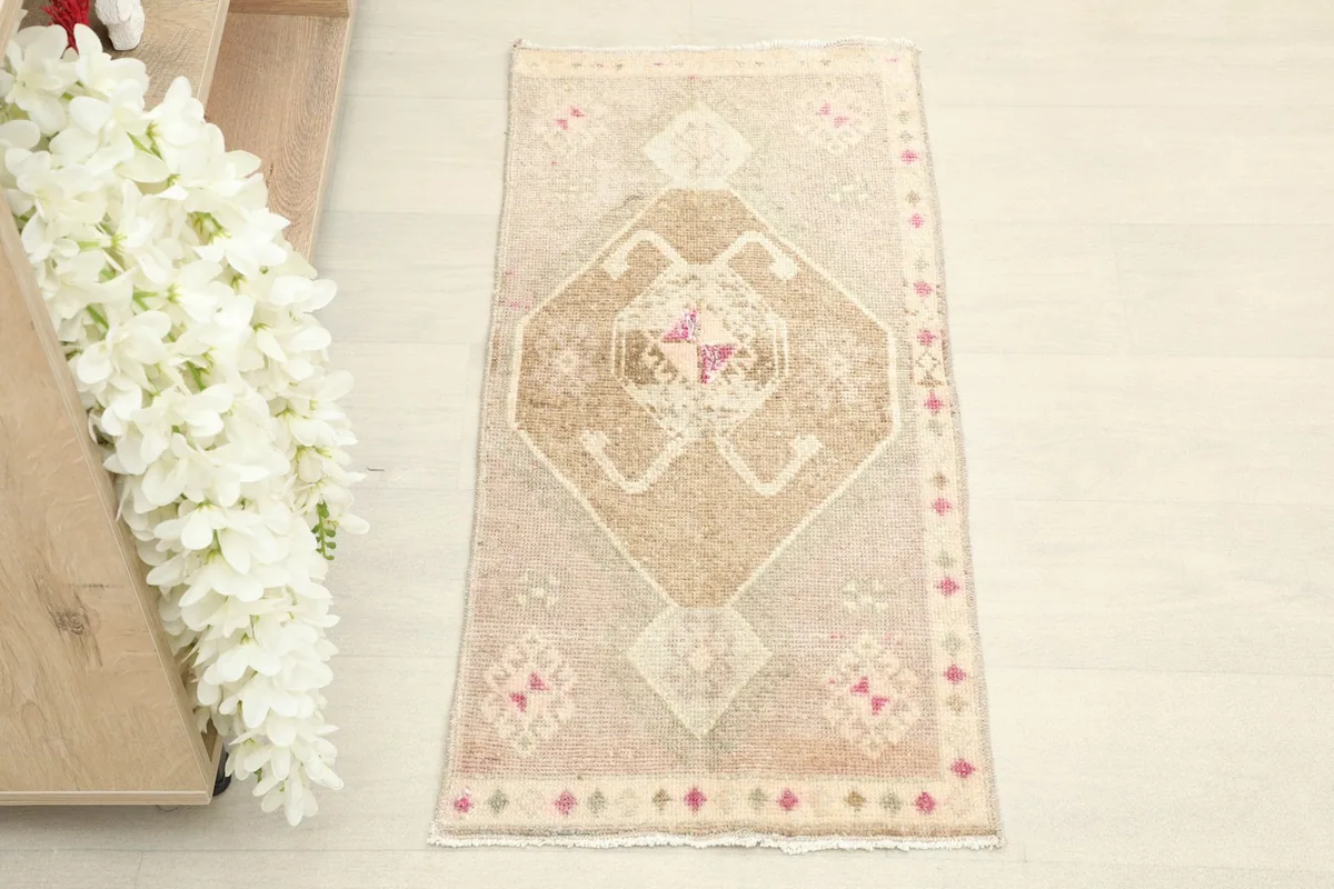 Direct overhead view of the vintage Anatolian rug, highlighting its central geometric pattern.