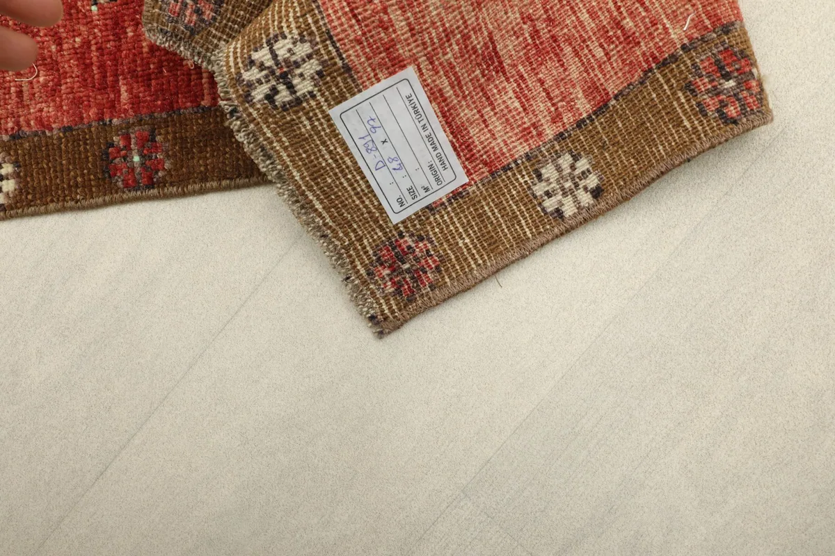 Close-up of the back of the rug, revealing the woven cotton foundation and a product label.