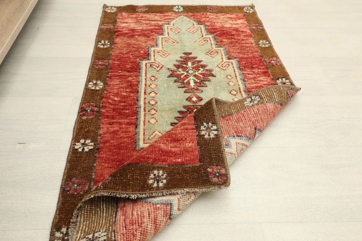 Rug partially folded, showcasing the full design and the flexibility of the vintage wool material.