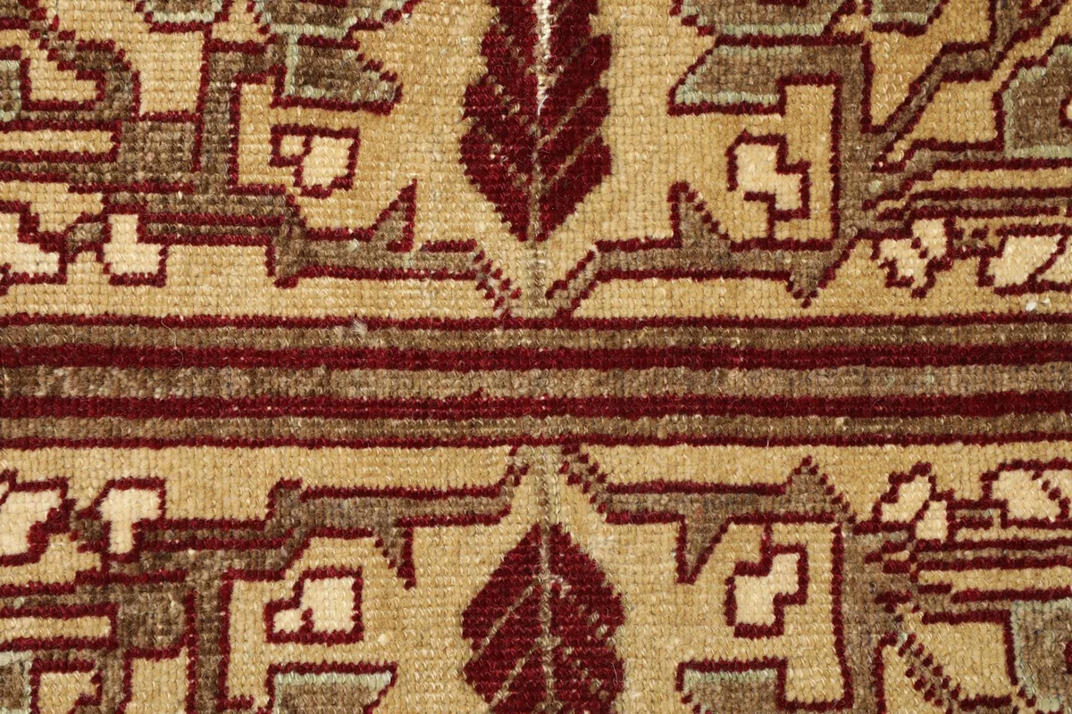 Detailed view of the hand-knotted red and tan tribal motifs