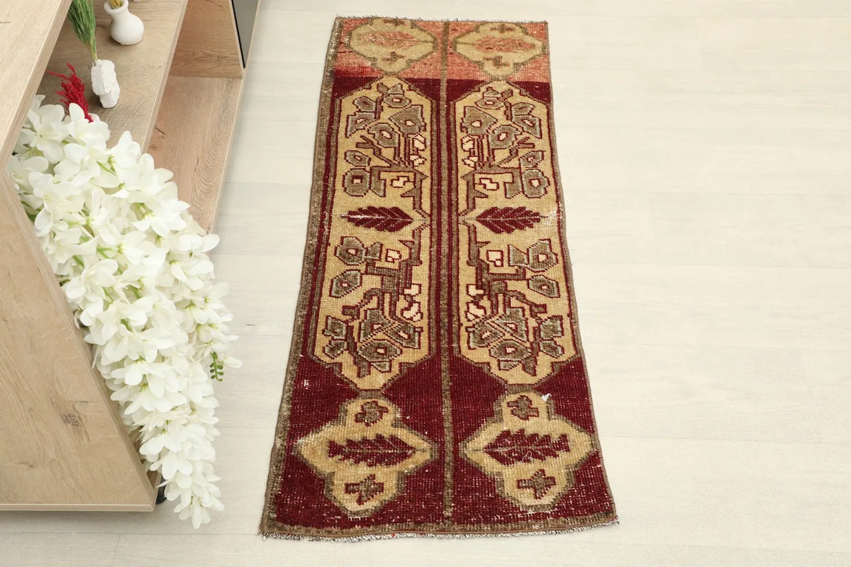 Top view of the small red and tan geometric area rug on a light floor