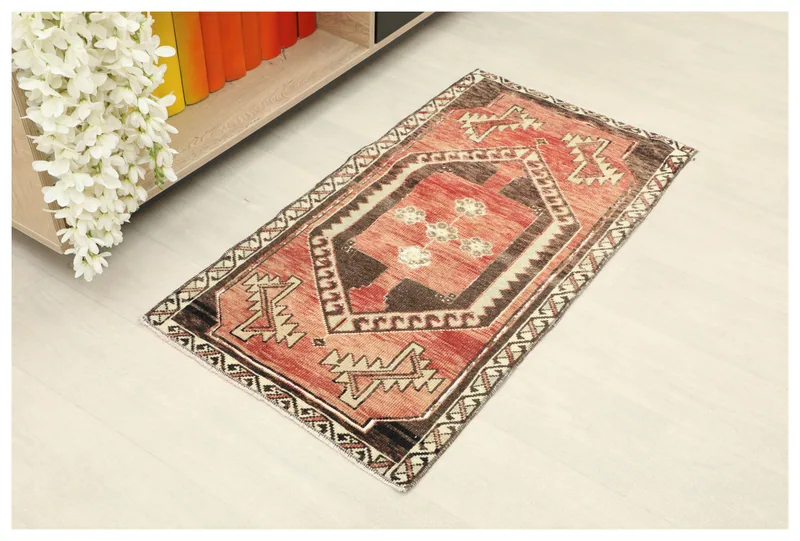 Full overhead view of the 1'10" x 3'5" vintage Anatolian doormat with red and brown geometric design