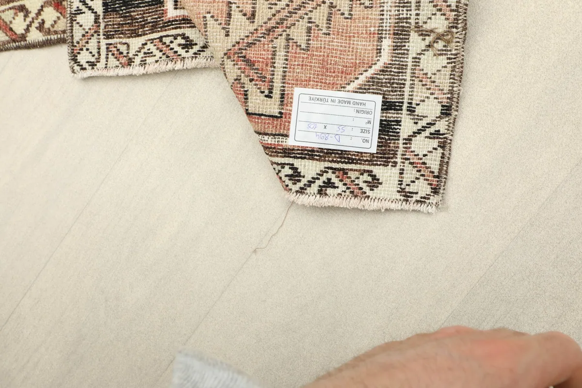 View of the rug's reverse side, showing the cotton foundation and a product label