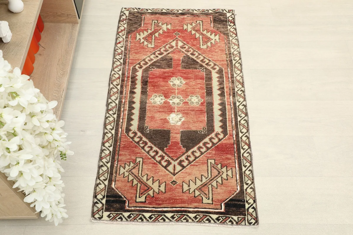 Top-down view of the red and brown tribal doormat, highlighting the central medallion and border patterns
