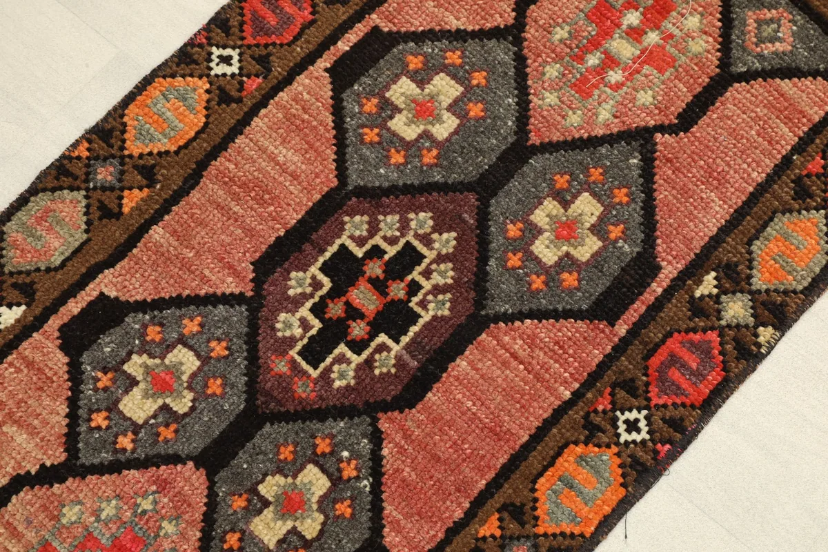 Angled view highlighting the texture and interconnected geometric medallions in rose, gray, and black.