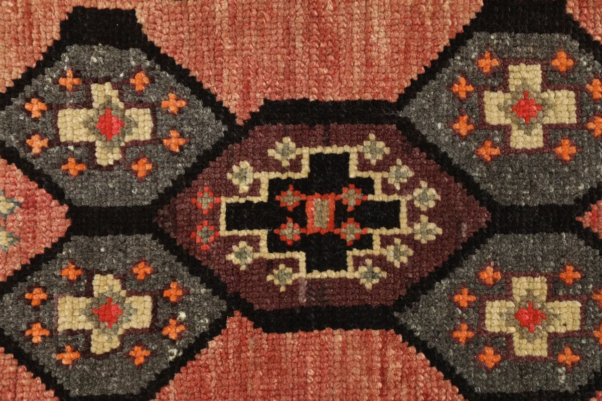 Close-up detail of the central geometric medallion with rose, gray, and black colors.