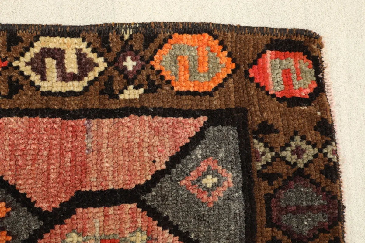 Close-up of the rug's edge, revealing the hand-knotted construction and varied yarn colors.