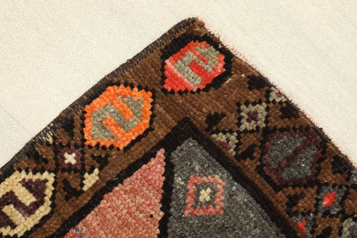 Corner detail showing the brown border with orange and red tribal motifs.