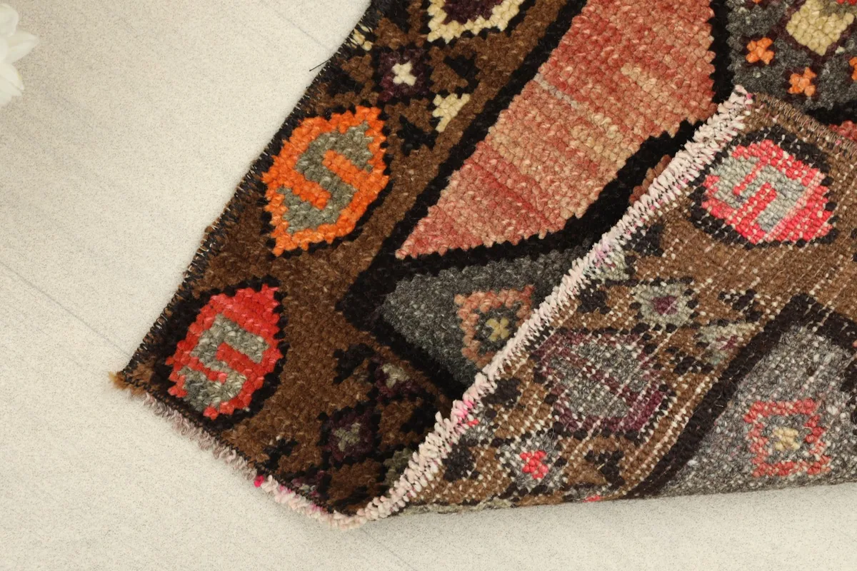 View of the low wool pile and the reverse side of the rug, showing its construction.