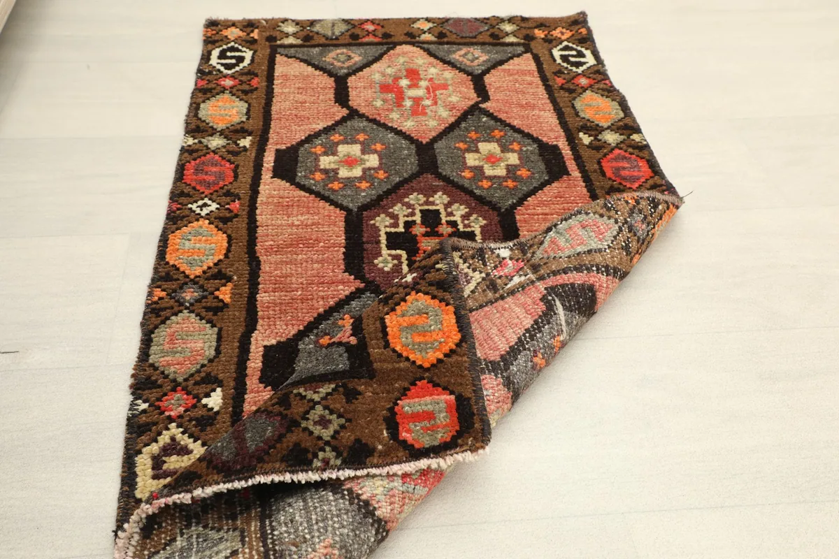 The rug partially folded, illustrating its flexibility and the texture of the wool pile.