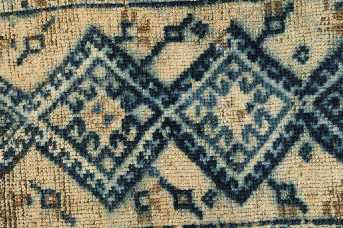 Detailed view of the intricate navy tribal diamond patterns and texture of the wool pile.