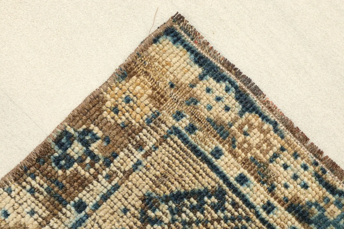 Close-up of a corner of the rug, showing the tight hand-knotted construction and color variations.