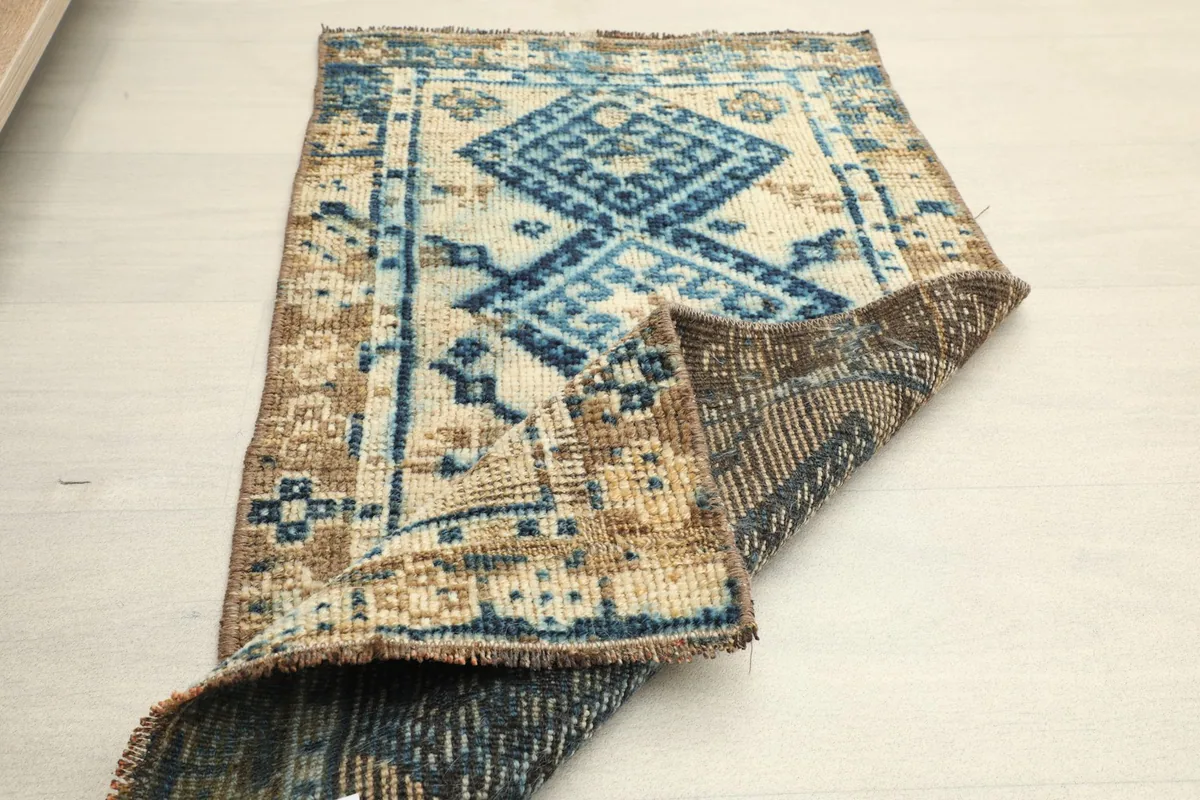 Partially folded rug showing the full pattern on one side and the sturdy construction of the back.
