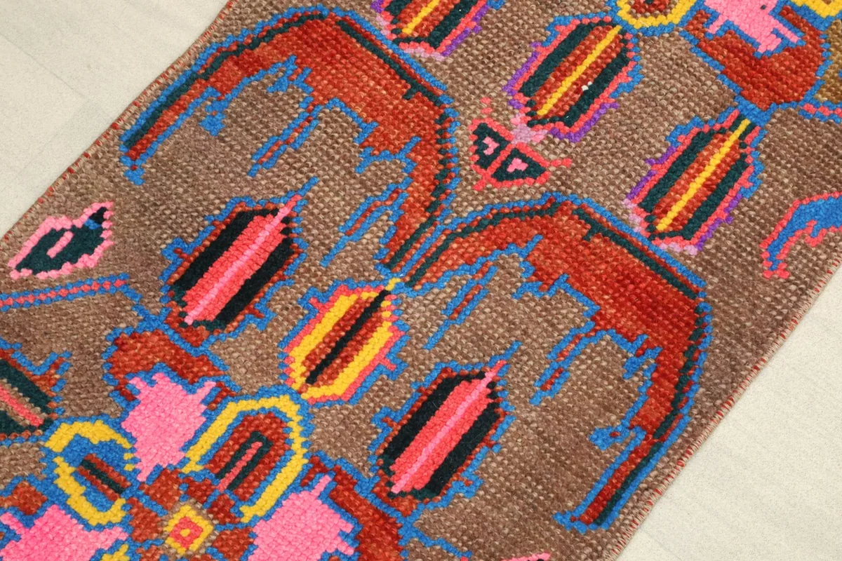 Close-up detail of the hand-knotted wool pile and vibrant colors in the central geometric design.