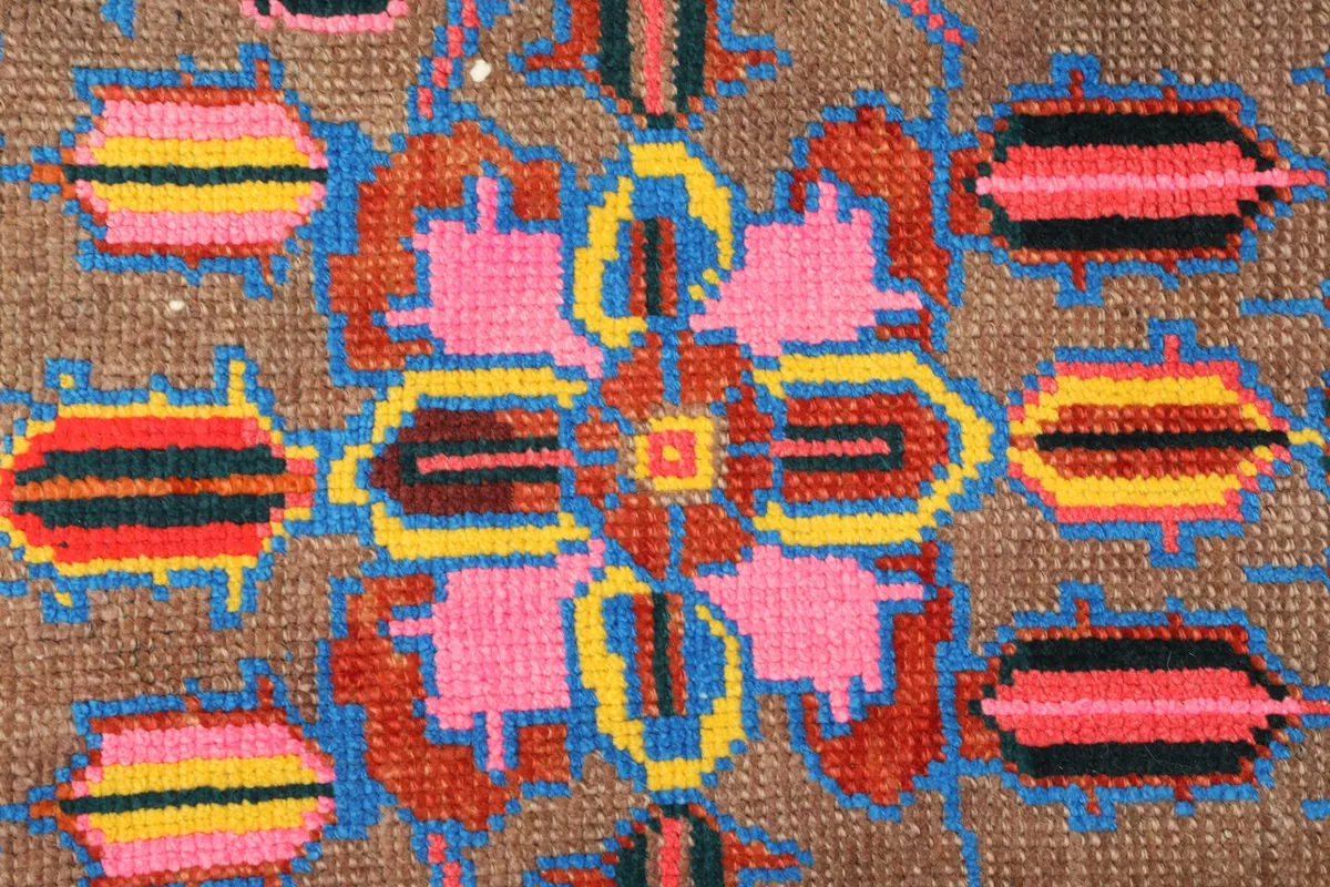 Detailed view of a central pink floral-like geometric motif and surrounding elements.