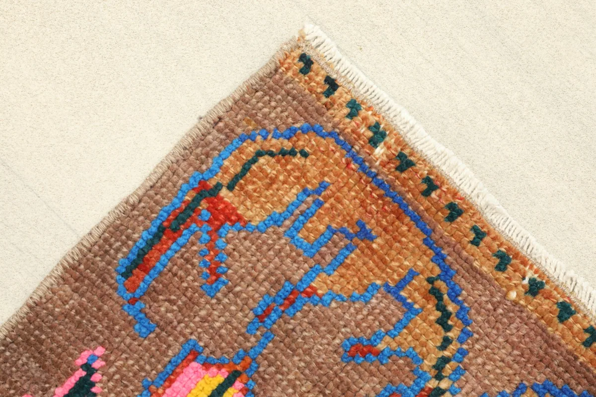 Corner view showing the edge finish and part of the blue and orange tribal border design.