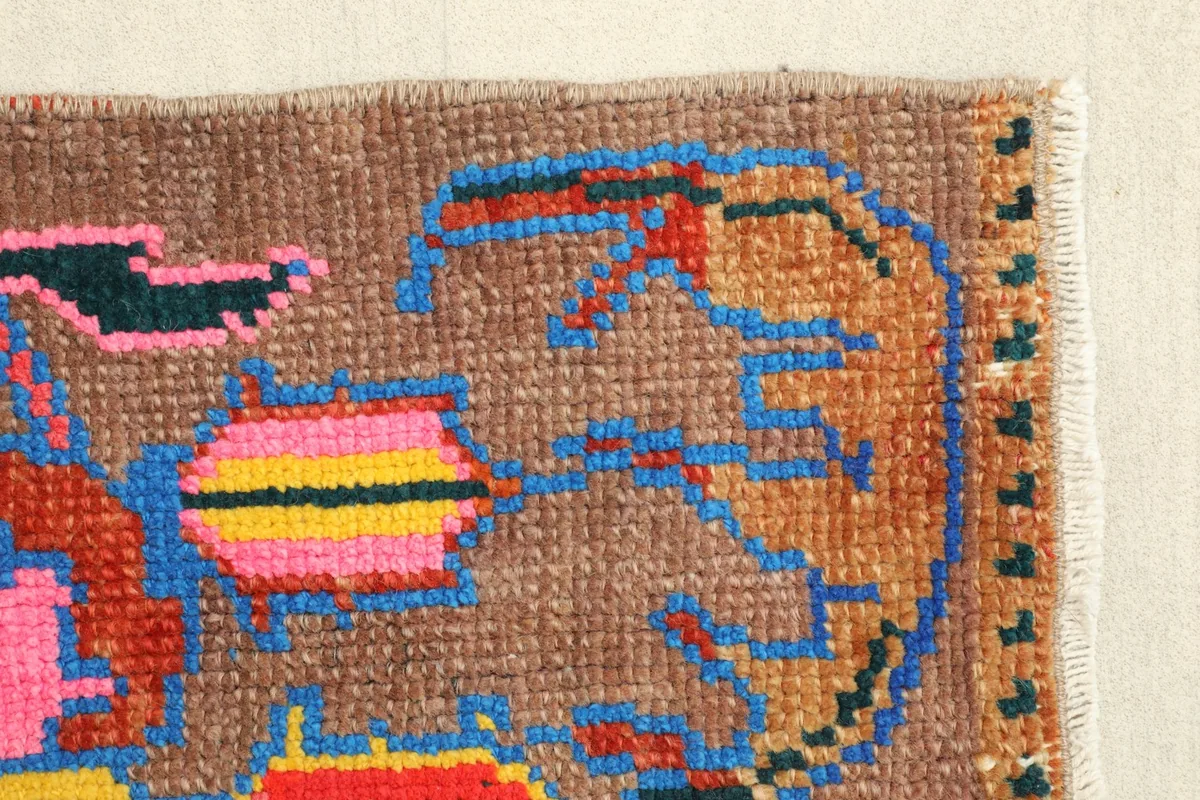 Another corner detail highlighting the hand-knotted texture and the outer green accents on the border.