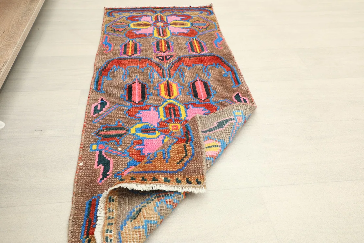 The doormat partially folded, showing the flexibility and thickness of the vintage wool pile.