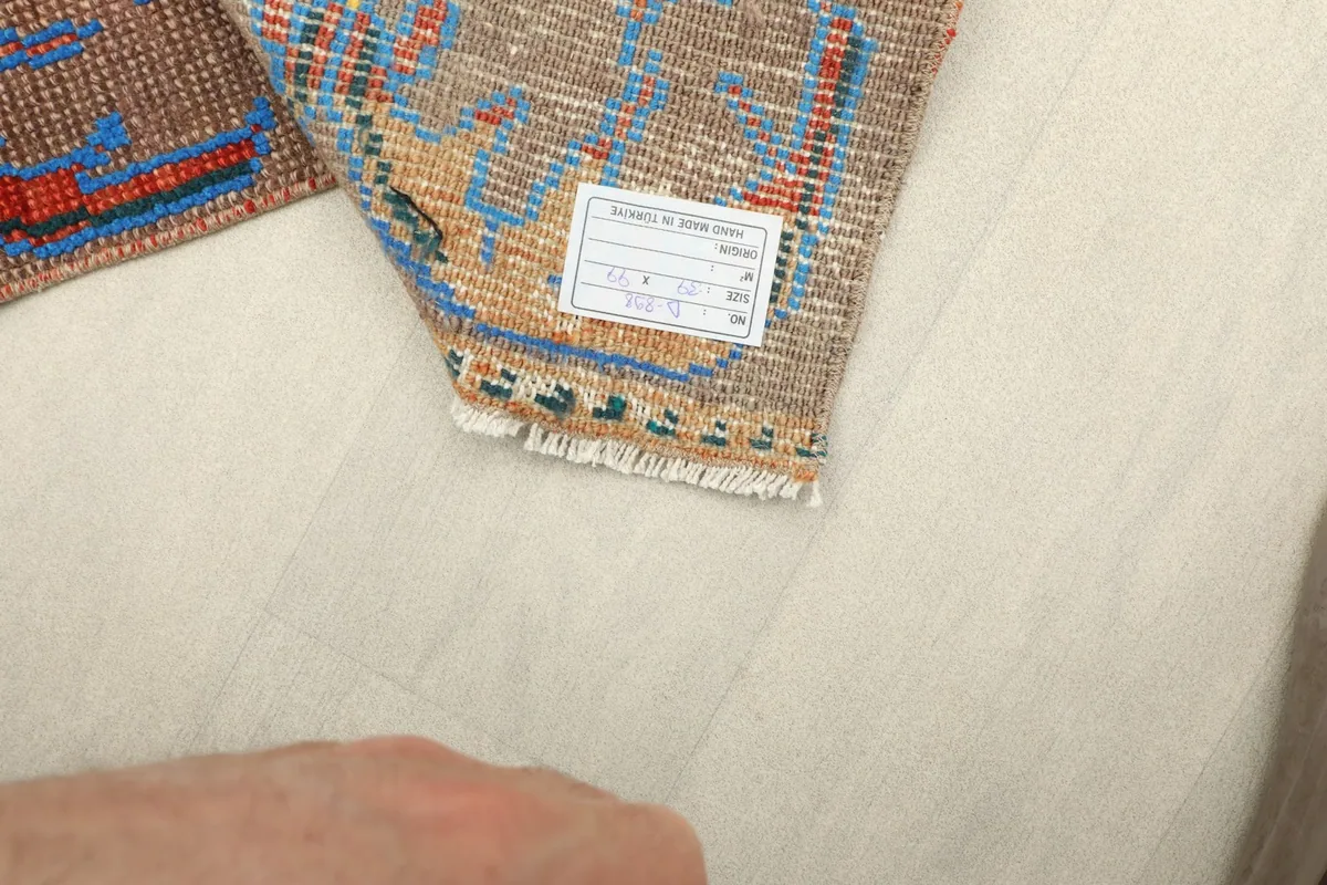Close-up of the care label attached to the back of the vintage hand-knotted doormat.