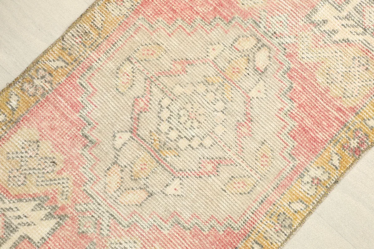 Angled view showing the central medallion and geometric details of the vintage doormat