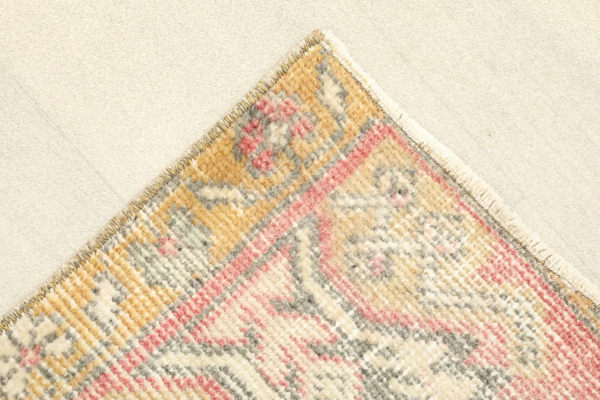 Corner detail of the rug, showing the gold border and subtle color variations