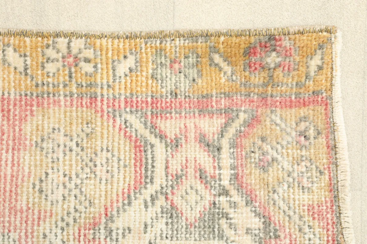 Detail of the rug's edge, showcasing the geometric patterns within the gold border