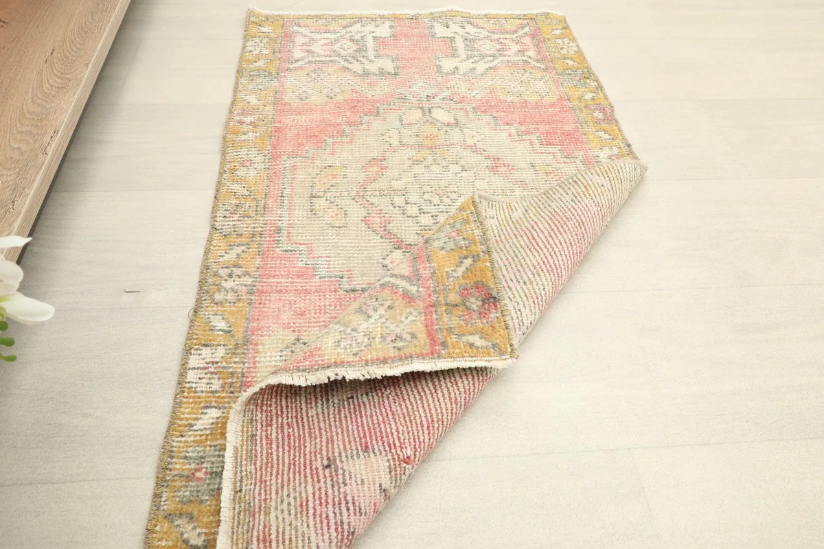 The small rug partially folded, revealing its backing and overall construction