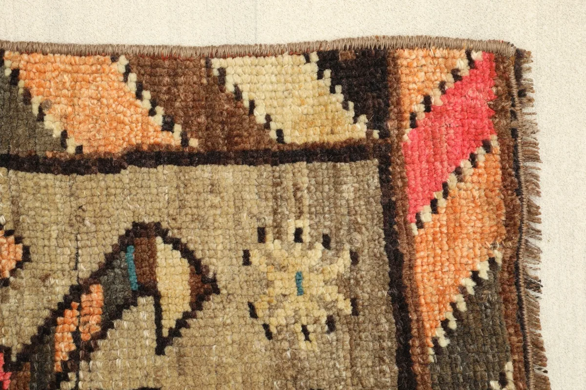 Close-up view of the low wool pile and the hand-knotted texture of the vintage rug.