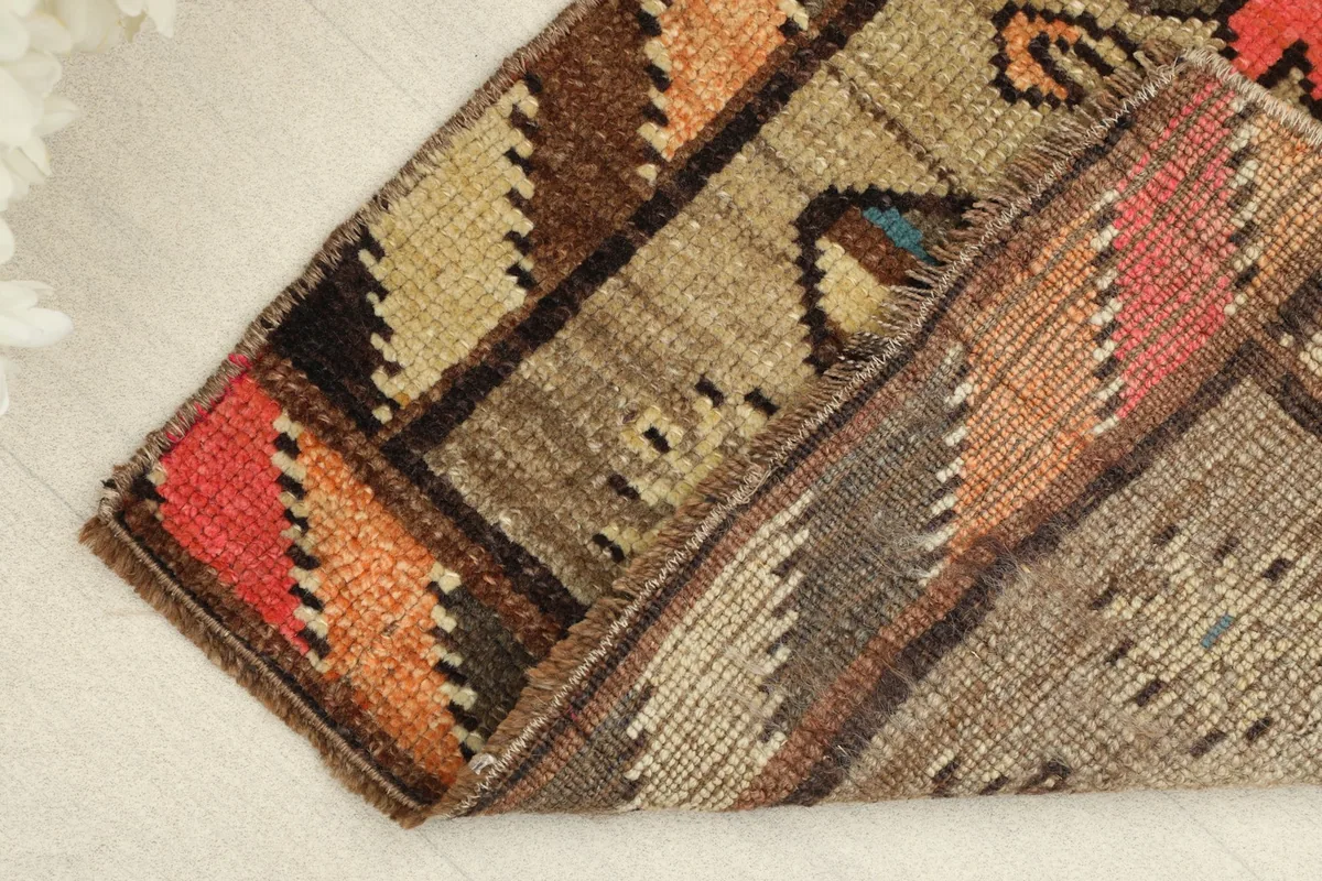 View of the rug folded, revealing the reverse side and the cotton foundation.