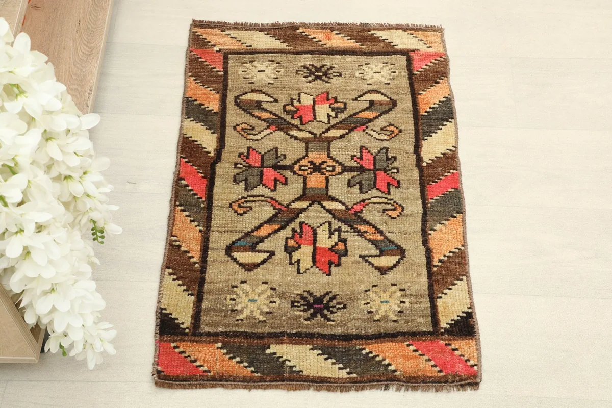 Overhead view of the small hand-knotted rug, highlighting its tribal medallion and geometric border.