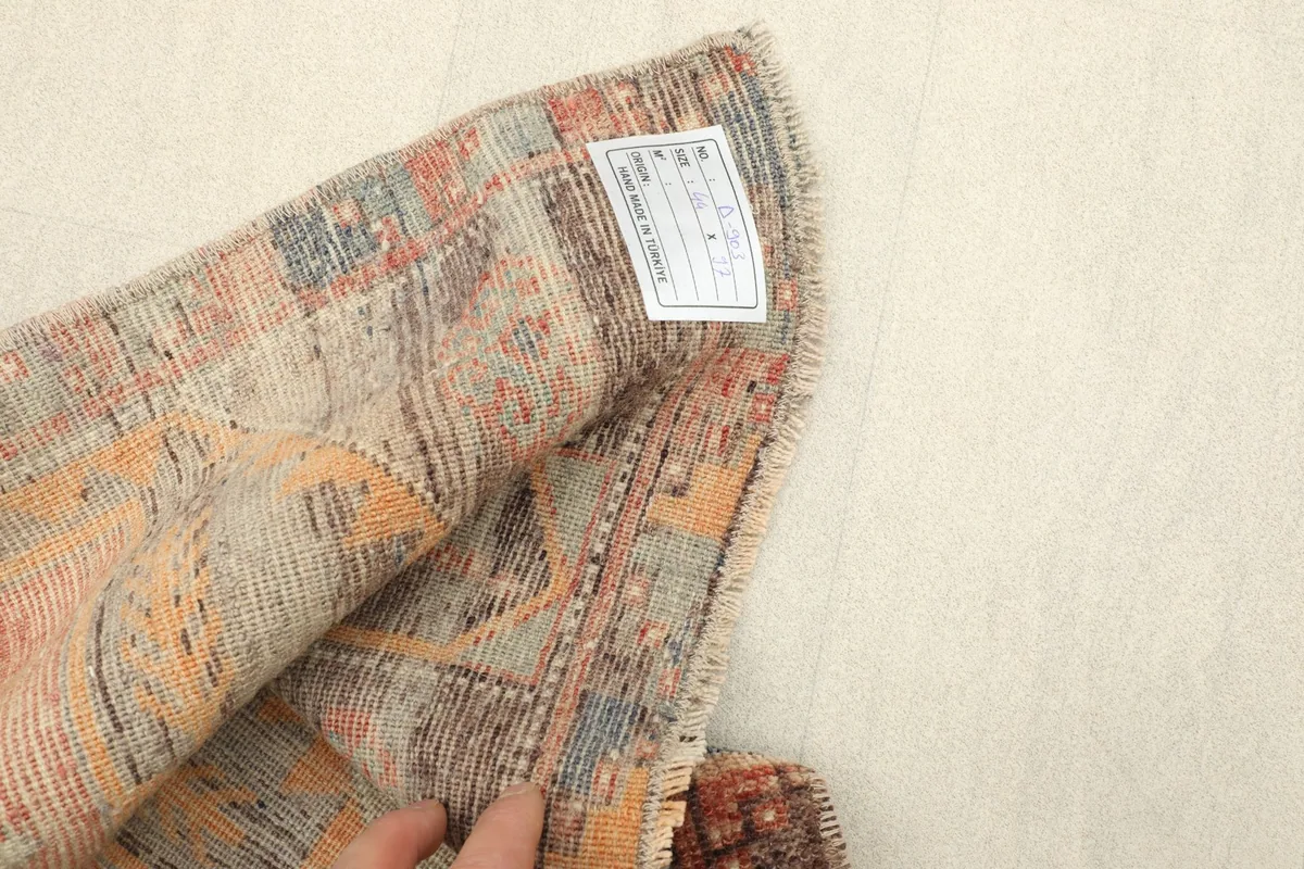 Close-up of the rug's back, revealing the cotton foundation and hand-knotted structure.