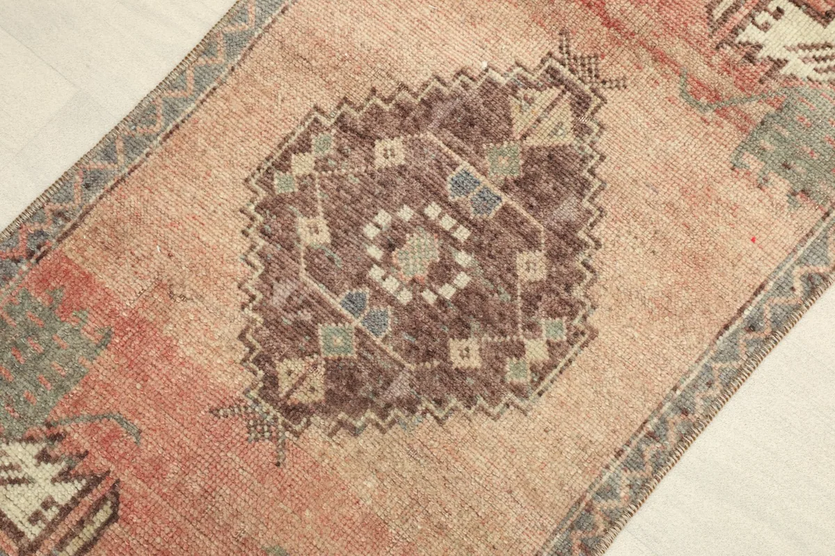 Close-up detail of the central medallion with brown, beige, and blue geometric patterns