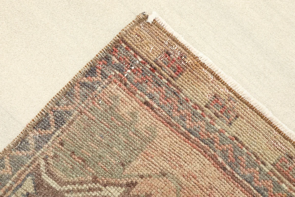 Corner detail showing the intricate border pattern and muted color variations