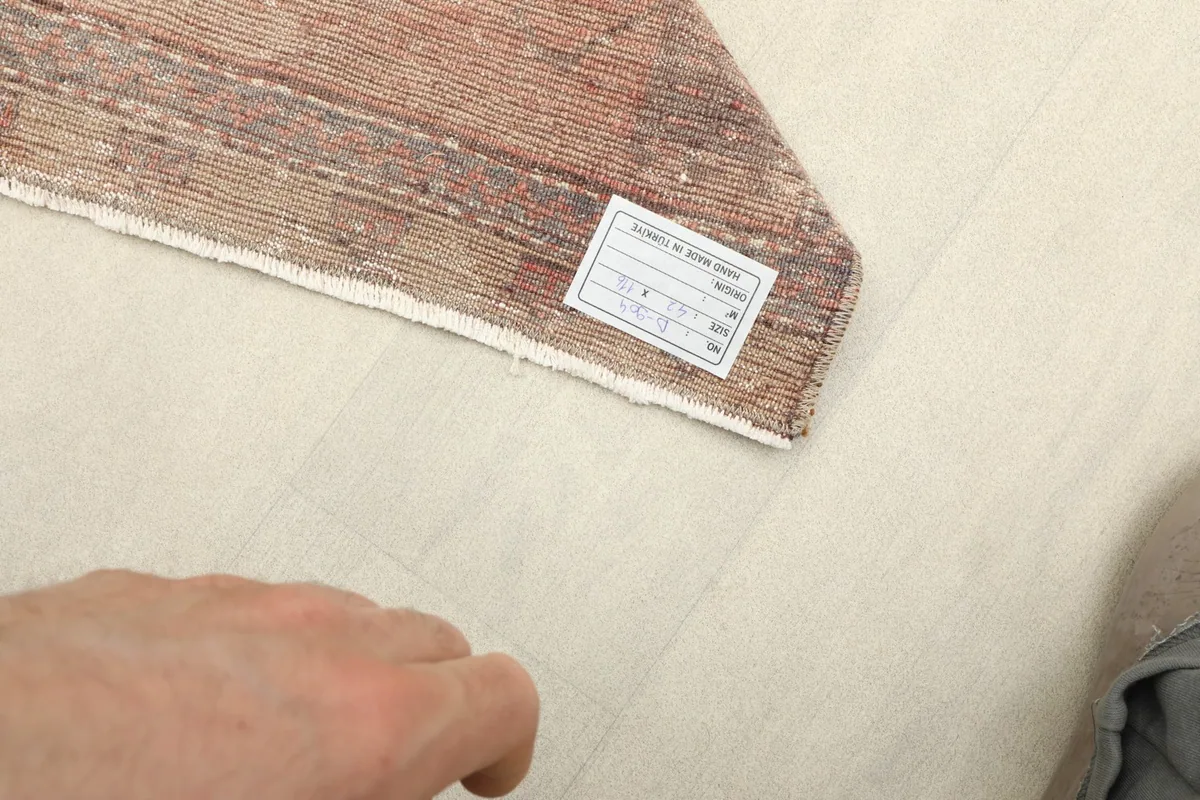 Close-up of the back of the rug, revealing the hand-knotted cotton foundation and wool pile