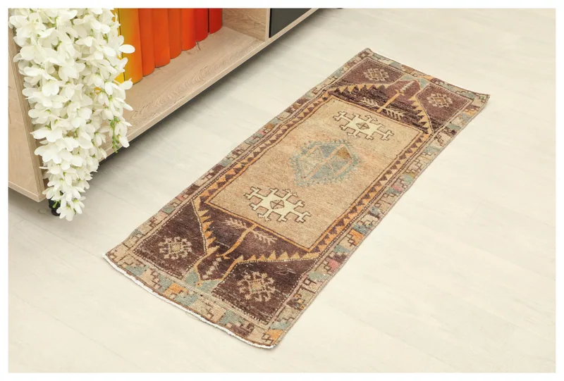 Full top view of the beige and brown tribal runner rug on a white background.