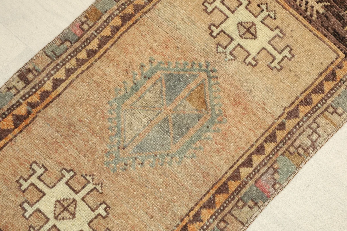 Close-up view of the central beige field with geometric motifs in blue, ivory, and brown.