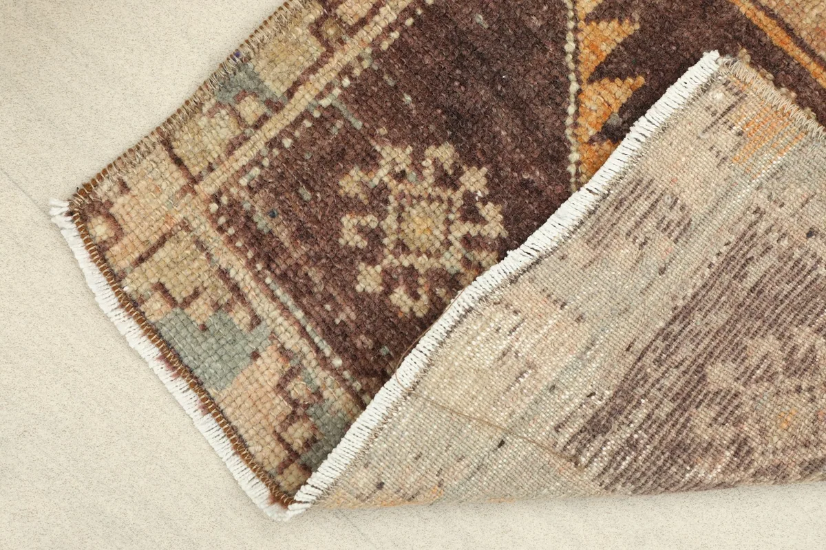 View of the rug's edge, revealing the low wool pile and cotton foundation.