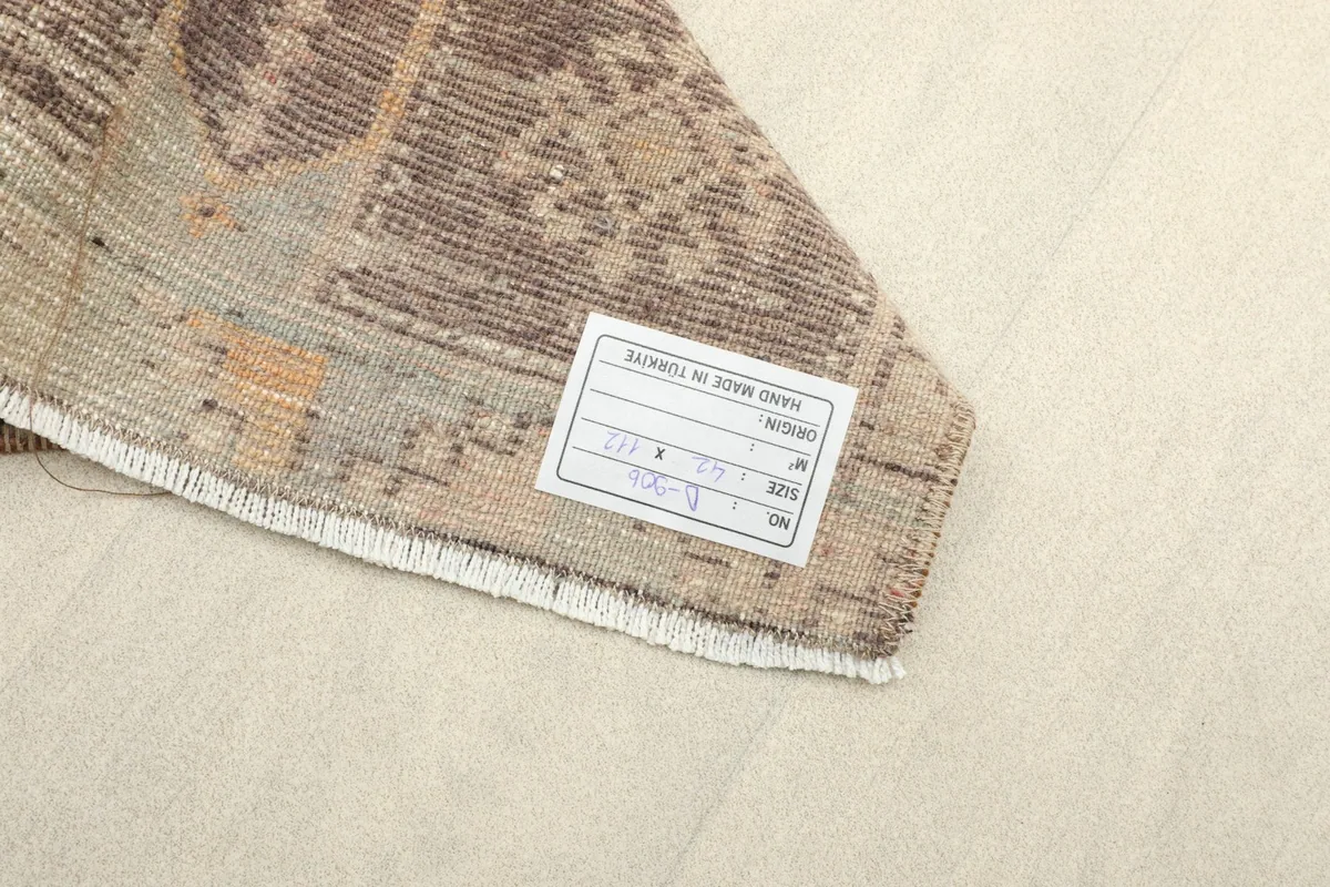 Underside of the rug showing the hand-knotted cotton foundation and product label.