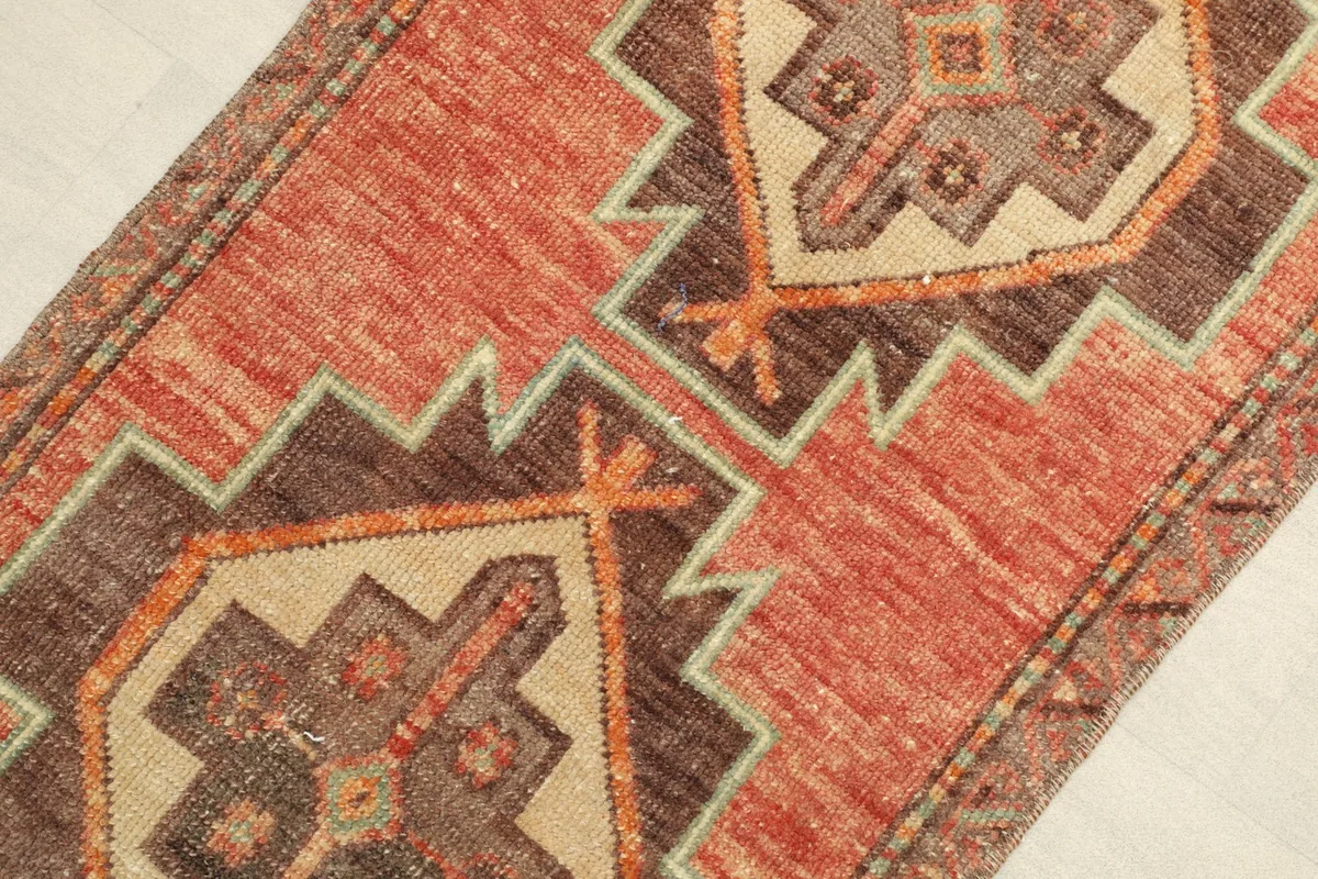 Angled close-up of the rug's surface, highlighting the geometric patterns and color variations.