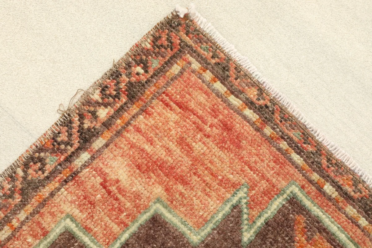 Close-up of a corner, showing the patterned border and the hand-knotted texture.