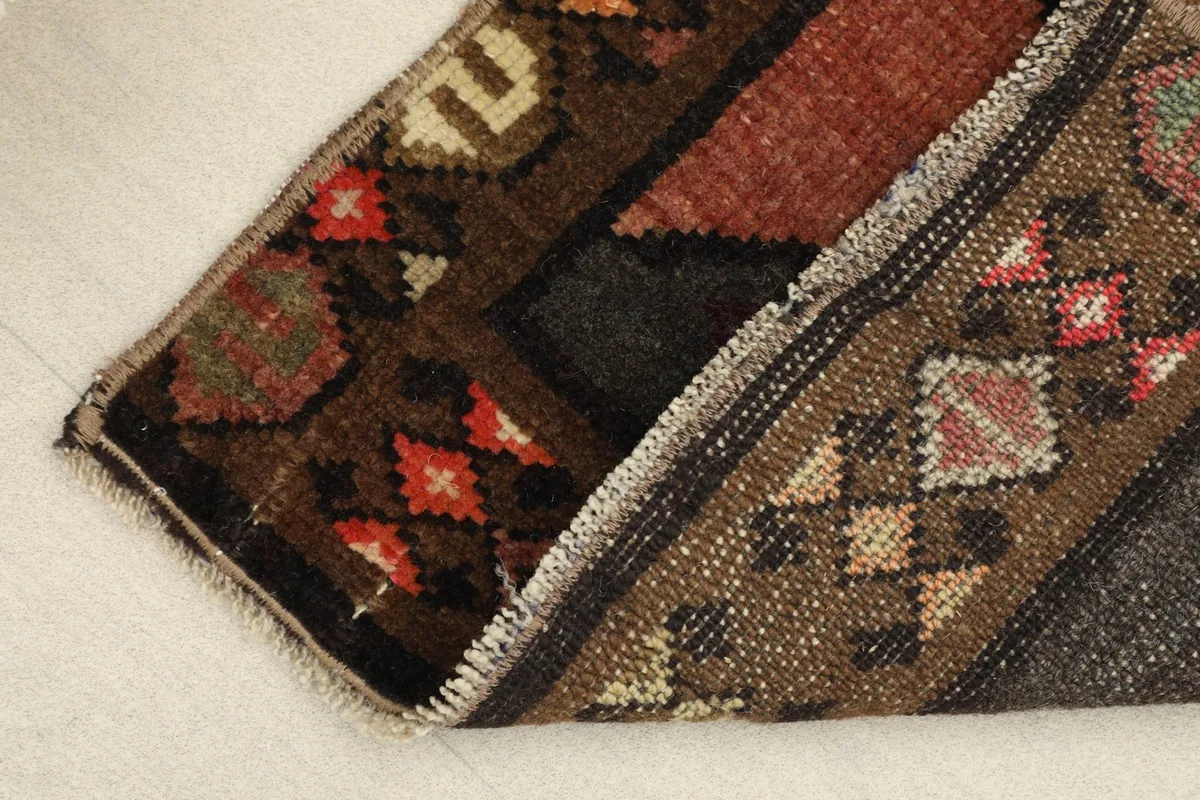 View of the rug folded to show the thickness of the wool pile and the cotton foundation.