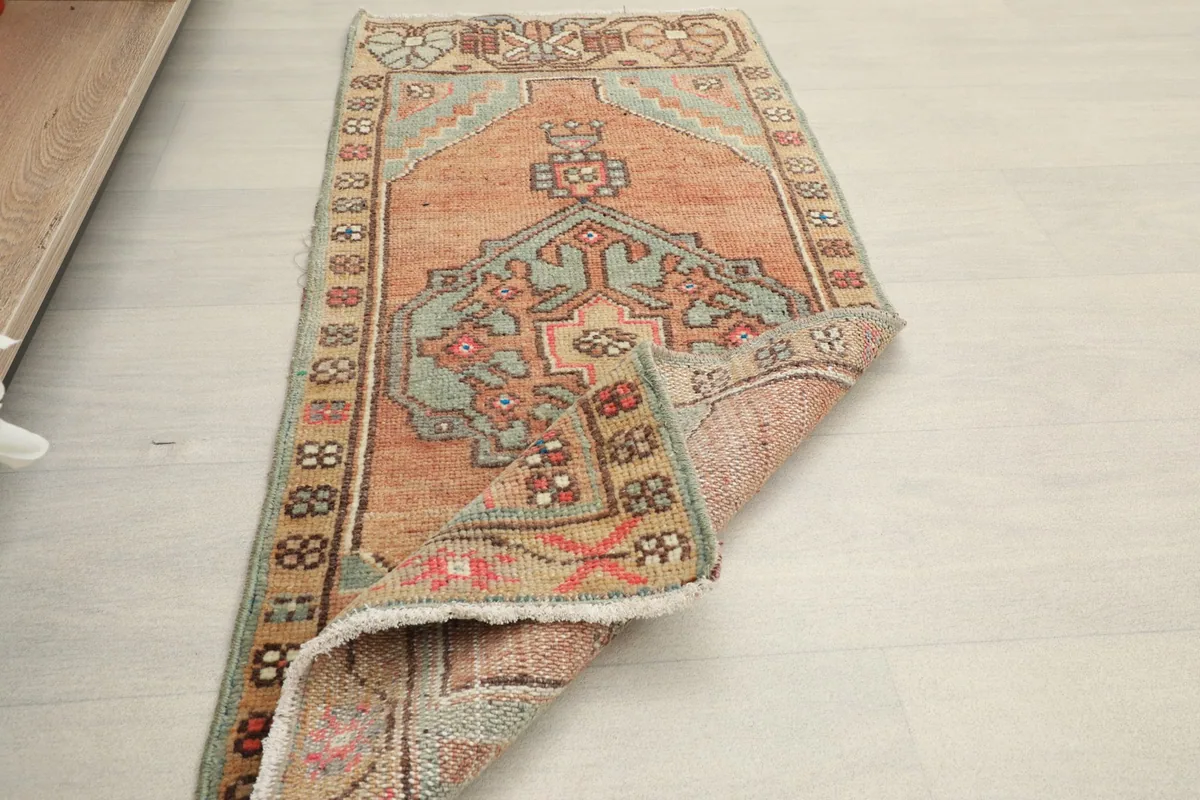 Angled view of the rug partially folded, displaying its overall design and texture.