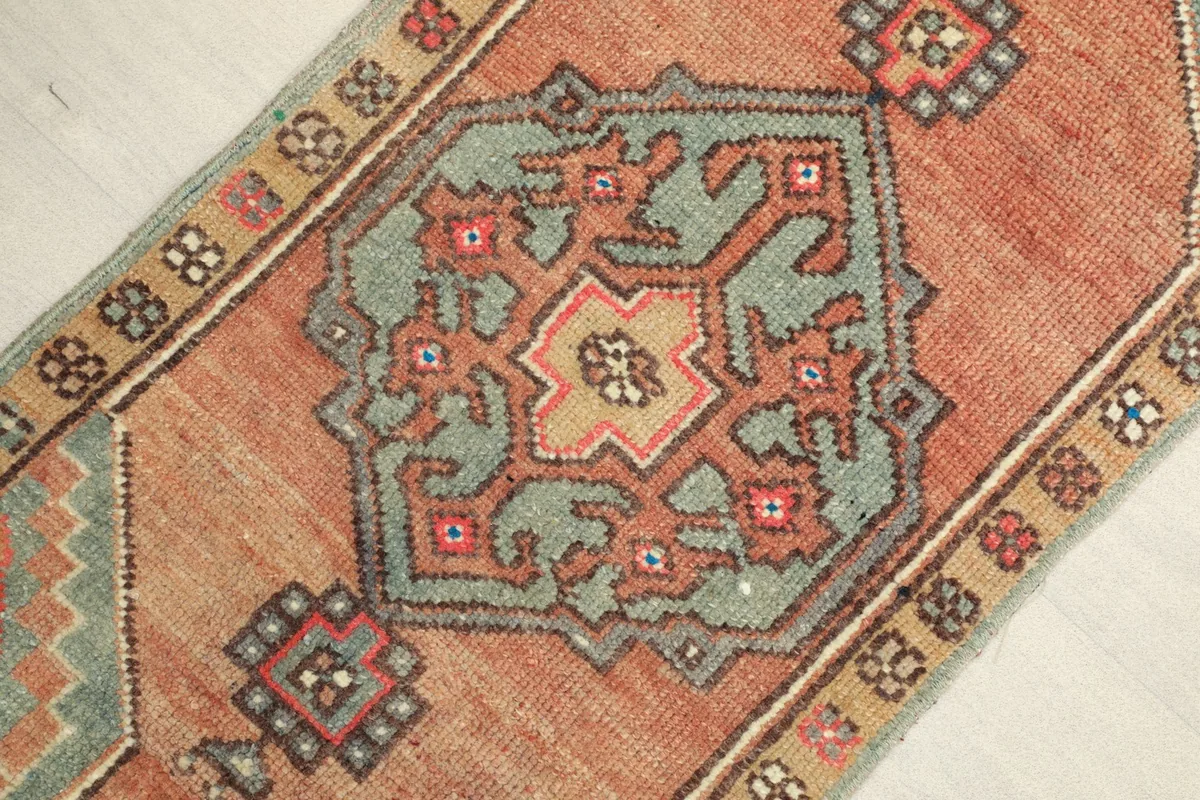 Close-up detail of the central blue geometric medallion and surrounding rust and beige patterns.