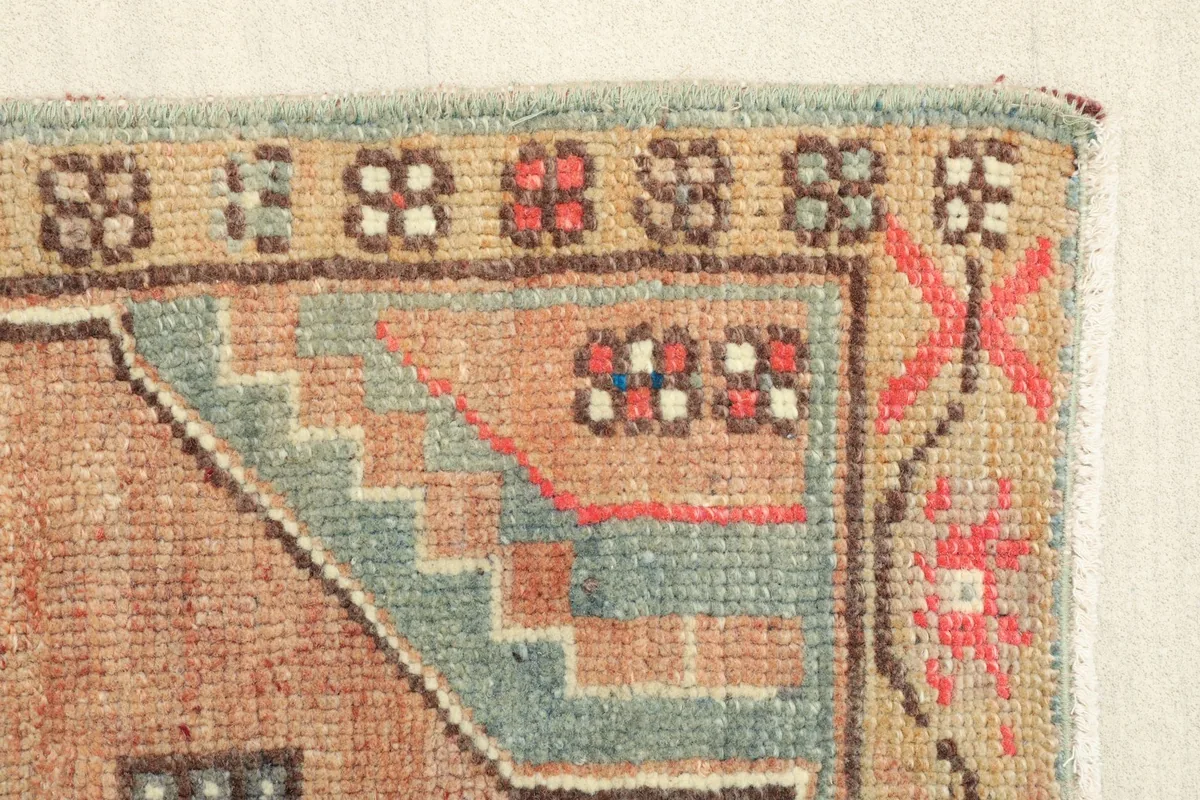 Close-up of the rug's edge, revealing the subtle color variations and hand-knotted texture.